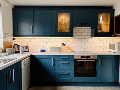 A kitchen with cabinets and appliances at Old Coastguard Cottages Amble