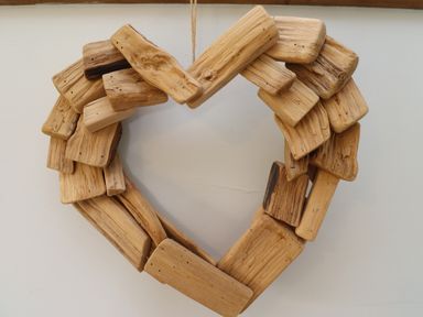 A heart shaped wreath made of wooden pieces hanging on a wall