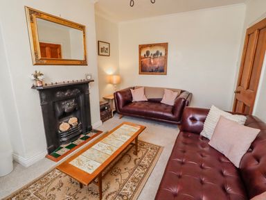 A living room with a fireplace and two sofas at Hardys House in Alnwick
