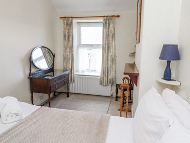 A bedroom with a bed and a dressing table at Hardys House Alnwick