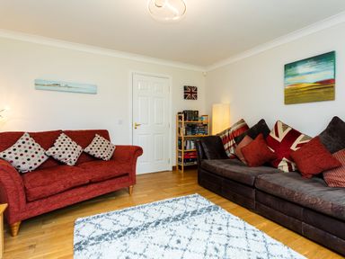 A living room with two sofas and a bookshelf at The Apartment in Bamburgh