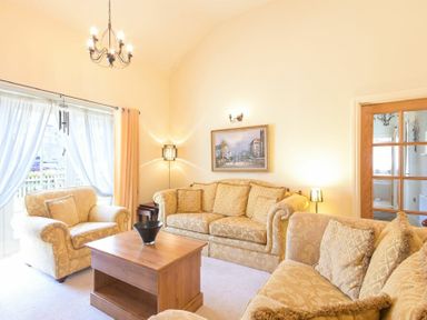 A living room with sofas wooden coffee table and a painting on the wall at Lavender Cottage Village Farm in Seahouses