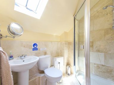 A bathroom with a sink toilet shower and a skylight at Lavender Cottage Village Farm in Seahouses