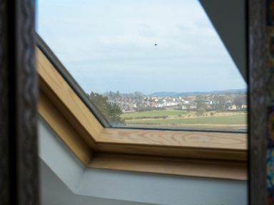 View through a skylight window showing fields and houses at Estuary View in Alnmouth