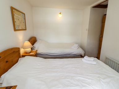 A bedroom with two beds and a map on the wall at Lavender Cottage (Bailiffgate) Alnwick