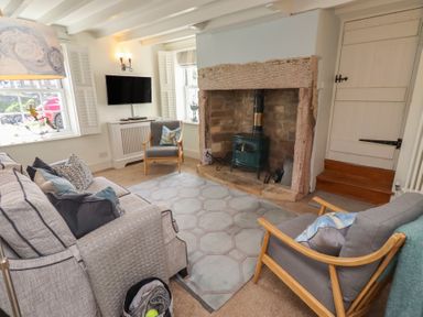A living room with a sofa and television at Marie's Cottage in Craster