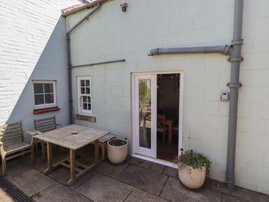 An outdoor seating area with a table and chairs at Marie's Cottage in Craster