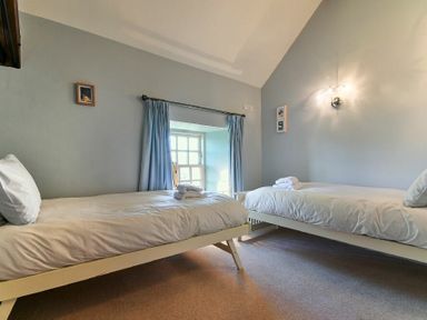 A bedroom with two single beds and folded towels on each bed at Budle Sands in Bamburgh