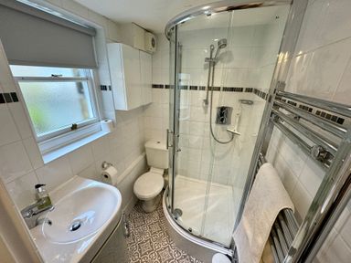 A bathroom with a shower enclosure toilet sink and towel rack at Dorothy Forster Court in Alnwick