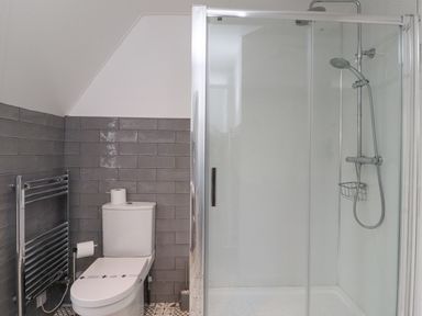 A bathroom with a toilet shower and heated towel rail at Whitestacks in Bamburgh