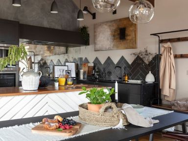 A kitchen with a countertop and wooden table with food and plants at Lantern View in Eglingham