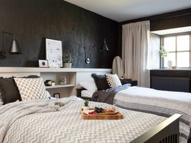 A bedroom with two beds a window with curtains and framed pictures on a shelf at Lantern View in Eglingham