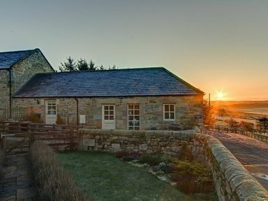 A stone house with slate roof and garden at sunset at Lantern View in Eglingham
