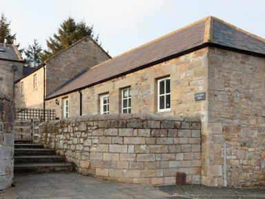 Stone buildings with slate roofs and a stone wall with steps at Lantern View in Eglingham