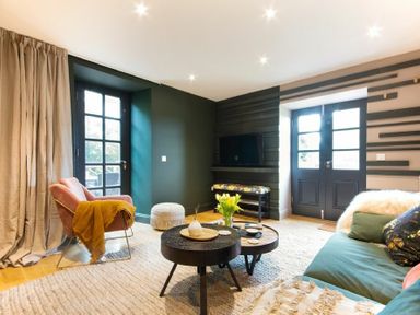 A living room with chairs coffee tables and double doors at The Bolthole in Eglingham