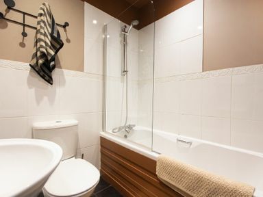 A bathroom with a bathtub shower toilet and towels at The Bolthole in Eglingham