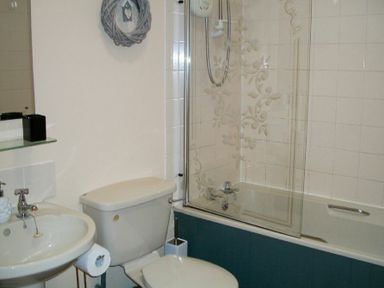 A bathroom with a sink toilet and bathtub with glass shower screen at Swallow Cottage nr Powburn in Powburn