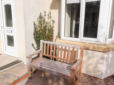 A bench beside a door and window at Beach View in Seahouses