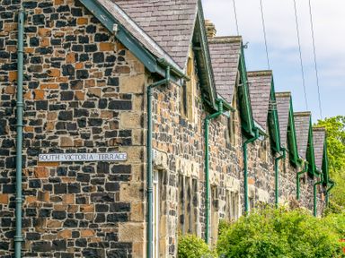 A row of stone terraced houses with green gutters and slate roofs at South Victoria Terrace