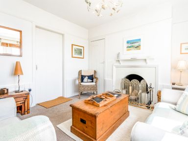 A living room with a wooden chest coffee table and a fireplace at Elliot Cottage in Bamburgh
