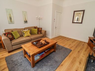 A living room with a sofa and coffee table at Alnbank in Alnmouth