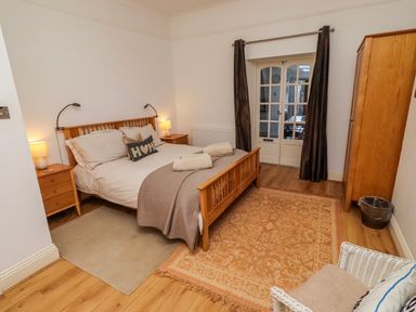 A bedroom with a bed, bedside tables and a wardrobe at Alnbank in Alnmouth