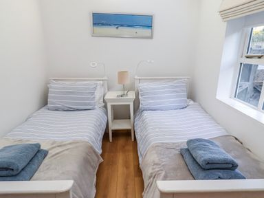 A bedroom with two beds and a bedside table at Alnbank in Alnmouth