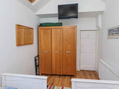A bedroom with a wardrobe and television at Alnbank in Alnmouth