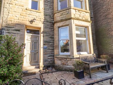 An entrance area with a door and bench at Alnbank in Alnmouth