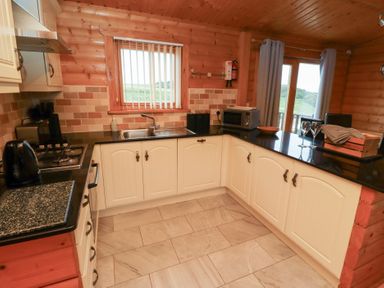 A kitchen with a sink and appliances at Heather Cottages - Brown Owl Bamburgh