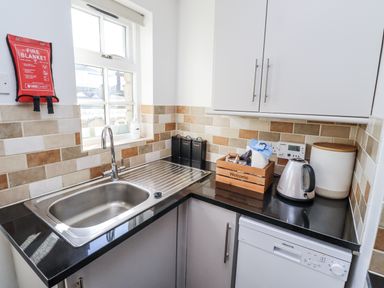 A kitchen with a sink and kettle at Heather Cottages - Godwit in Bamburgh