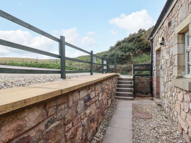 An outdoor path with steps leading to a cottage at Heather Cottages - Grayling in Bamburgh