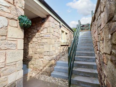 An outdoor area with stairs leading up to a building at Heather Cottages - Grey Seal Bamburgh