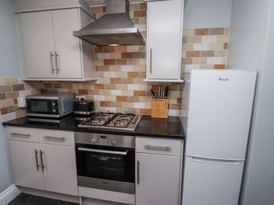 A kitchen with various appliances at Heather Cottages - Plover in Bamburgh