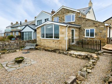 A stone house with gravel yard bench and stone planter at Island View in Amble