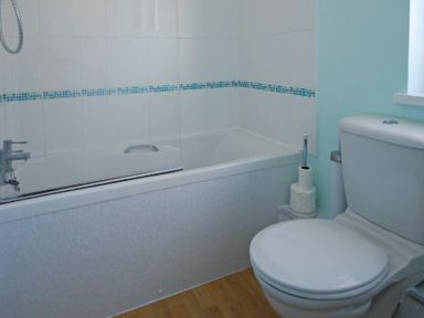 A bathroom with a bathtub and a closed toilet seat at Longstone in Embleton