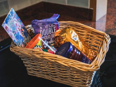A wicker basket with cookies tea a jar of jam and a card on a kitchen counter at Mid Cote in Shoreston near Bamburgh