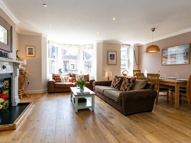 A living room with two sofas a coffee table and a dining table with chairs at Upper Alnbank in Alnmouth