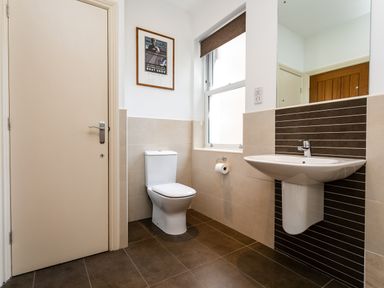 A bathroom with a toilet sink and a window at Upper Alnbank in Alnmouth
