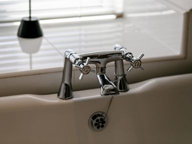 A bathtub faucet with hot and cold handles and a drain at Upper Alnbank in Alnmouth