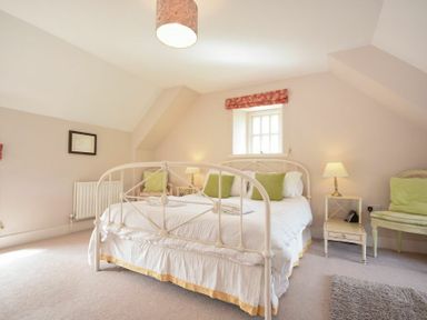 A bedroom with a double bed green pillows bedside tables lamps and a window at Sea Breeze in Newton-by-the-Sea