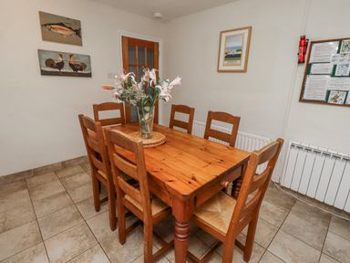 A dining room with a wooden table and chairs at St Marys Cottages No4 Low Newton-by-the-Sea