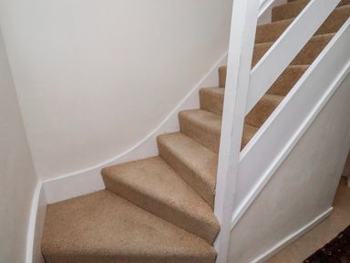 A staircase with carpet and a handrail at St Marys Cottages No4 Low Newton-by-the-Sea