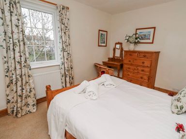 A bedroom with a bed and dresser at St Marys Cottages No4 Low Newton-by-the-Sea