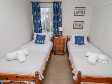 A bedroom with two beds and a bedside table at St Marys Cottages No4 in Low Newton-by-the-Sea