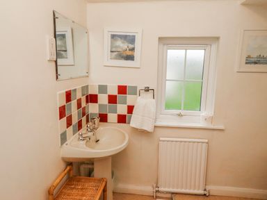 A bathroom with a sink and mirror at St Marys Cottages No4 Low Newton-by-the-Sea