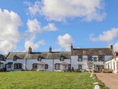 An outdoor area with a building and seating at St Marys Cottages No4 Low Newton-by-the-Sea