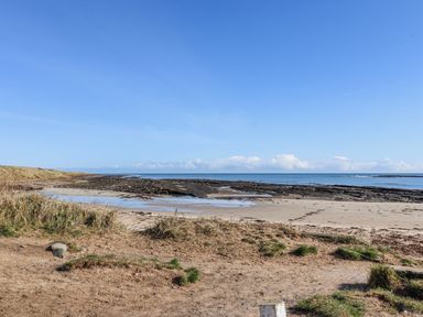 A beach area with rocks and ocean at St Marys Cottages No4 Low Newton-by-the-Sea