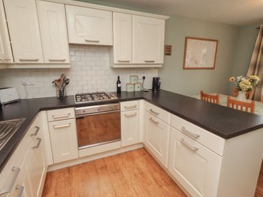 A kitchen with a stove and sink at Sugar Sands in Longhoughton