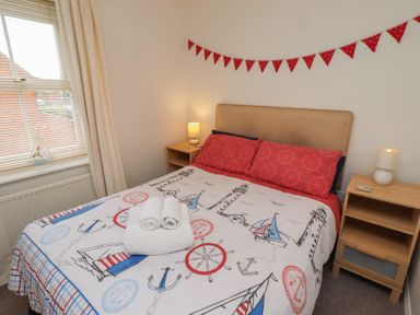 A bedroom with a bed and lamp at Sugar Sands in Longhoughton
